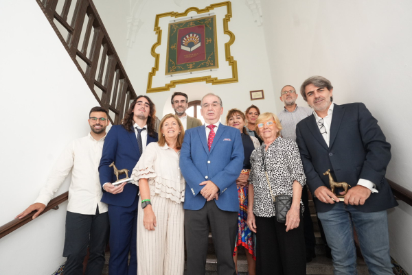 El decano junto a su equipo y varios de los homenajeados posan en la escalera donde se ha hecho la intervención de acondicimiento.